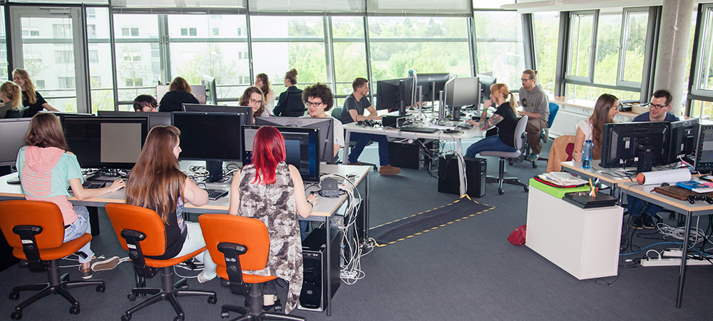 Sechzehn Studierende sitzen im Games-Lab an den PC-Arbeitsplätzen und arbeiten an ihren Games-Projketen.