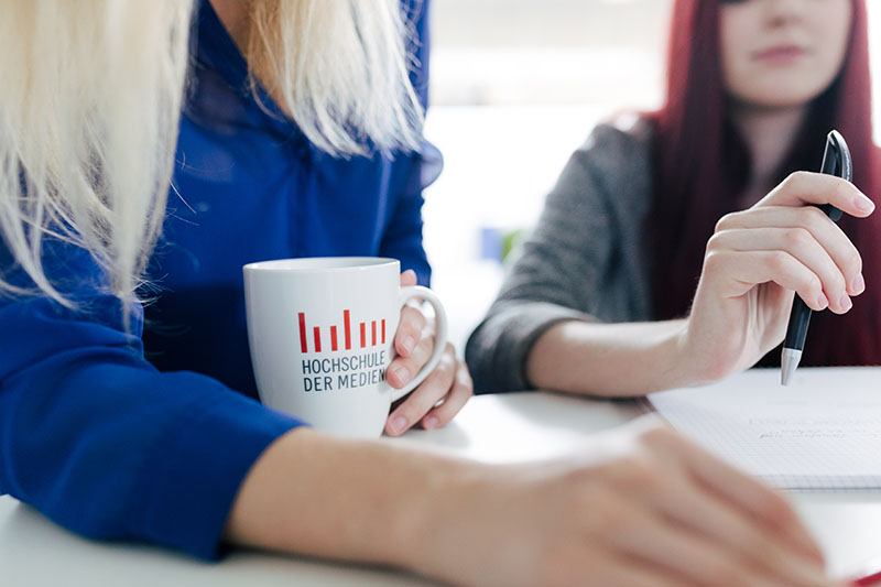 Studierende mit Tasse in der Hand