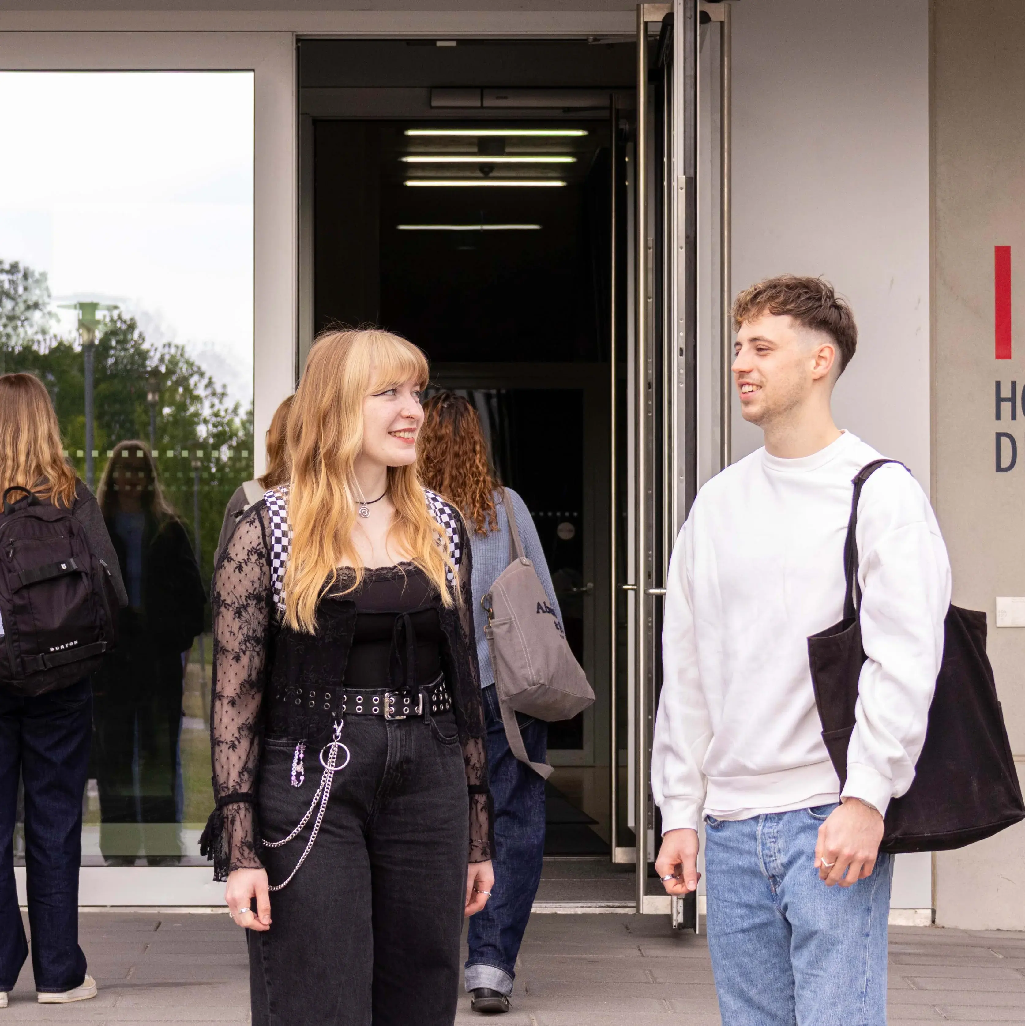 Studierende unterhalten sich vor dem sogenannten Würfel, einem Nebengebäude der Hochschule der Medien.