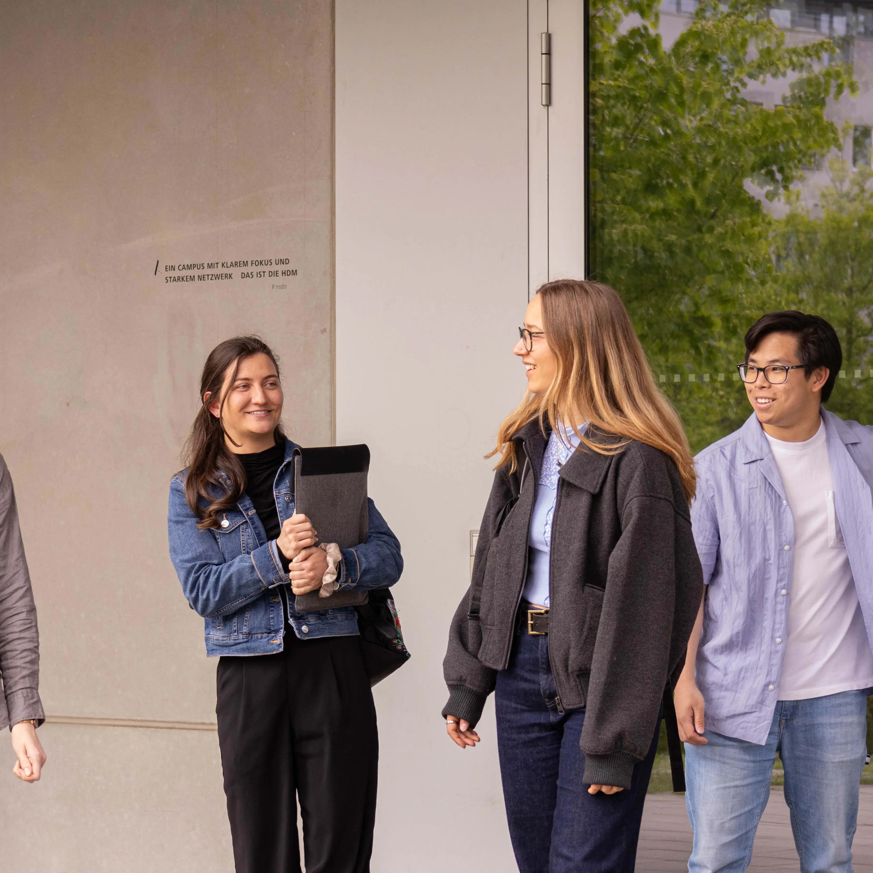 Studierende unterhalten sich beim Verlassen der Hochschule der Medien.