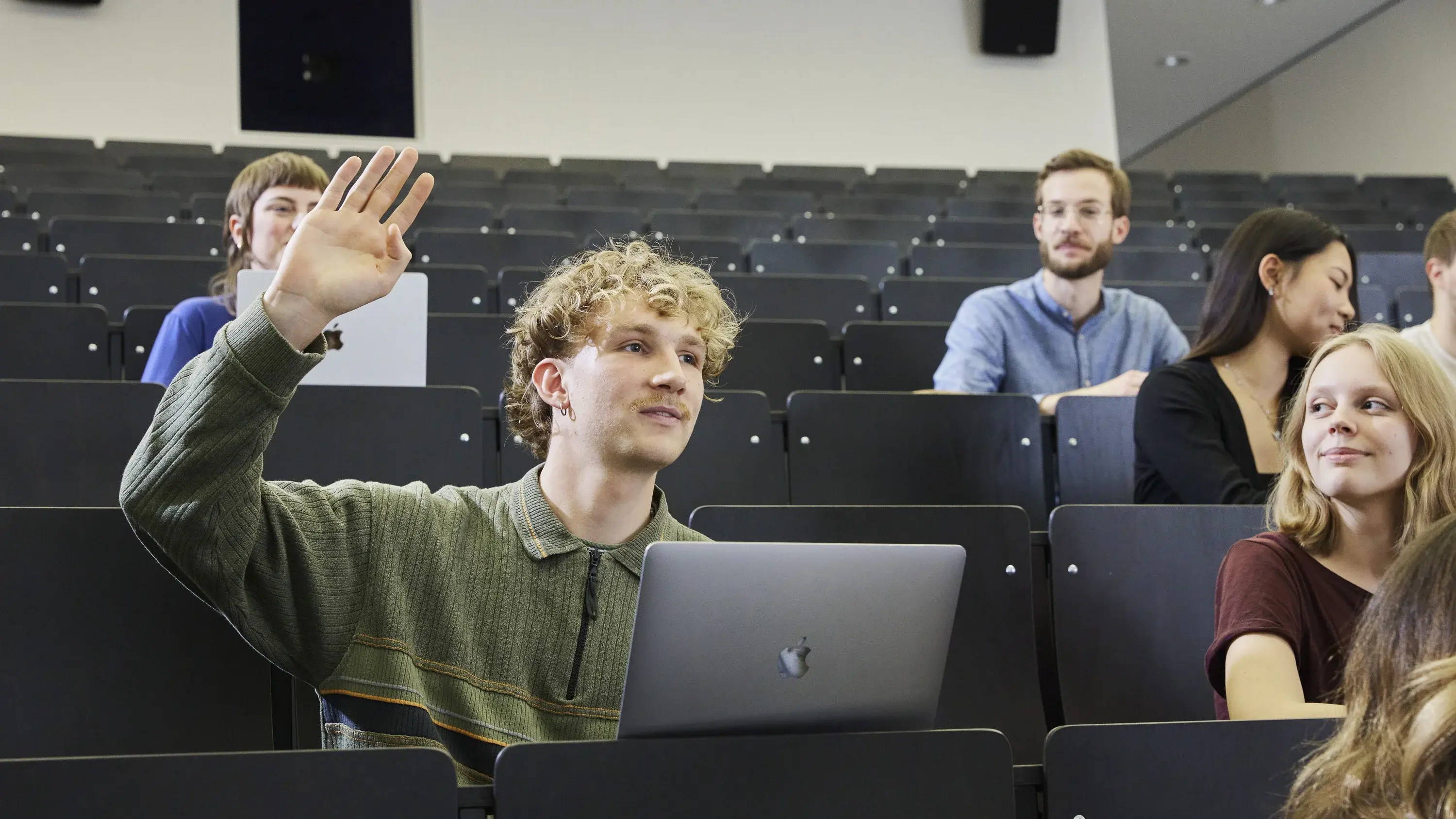 A student raises his hand during a lecture.