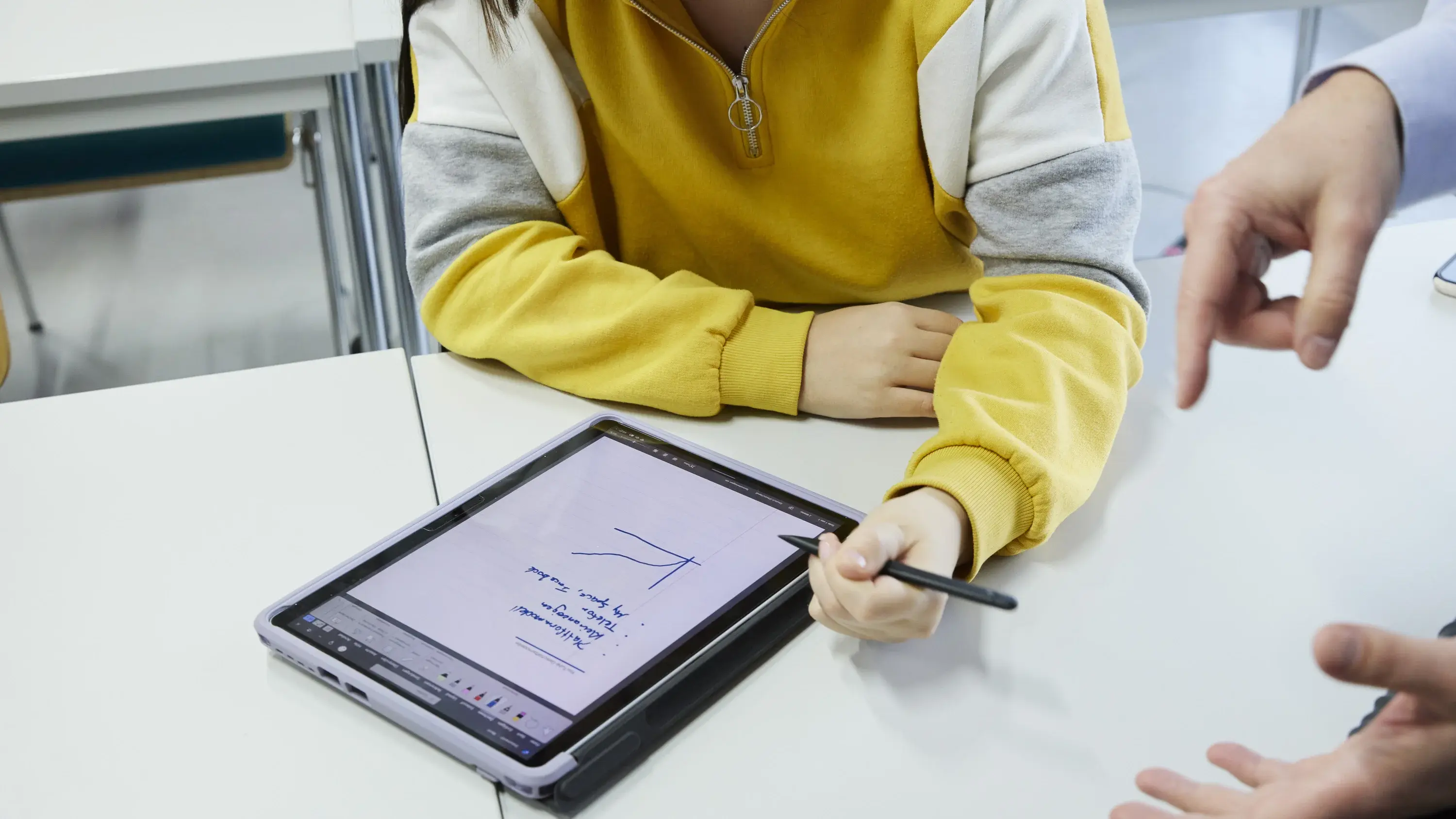 Eine Studierende arbeitet am Tablet in einer Vorlesung.