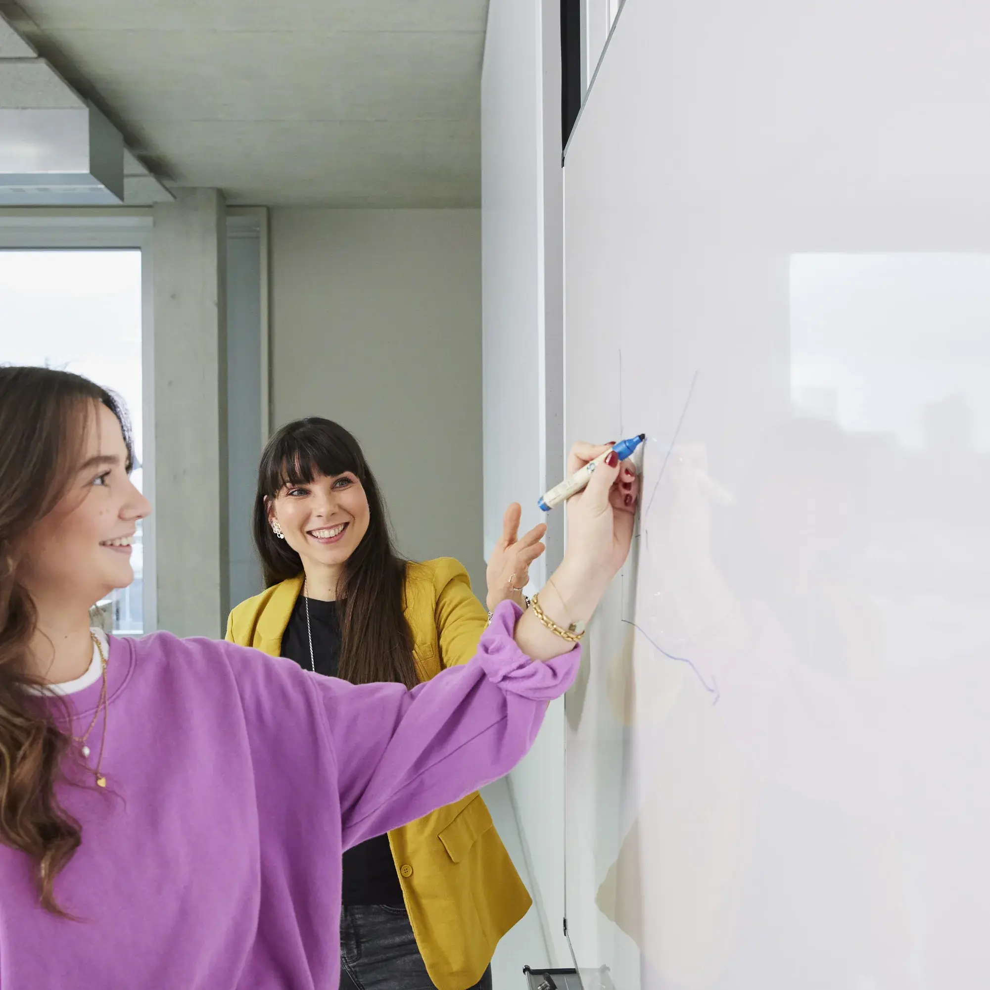 Eine Professorin hilft einer Studentin in einer Vorlesung.