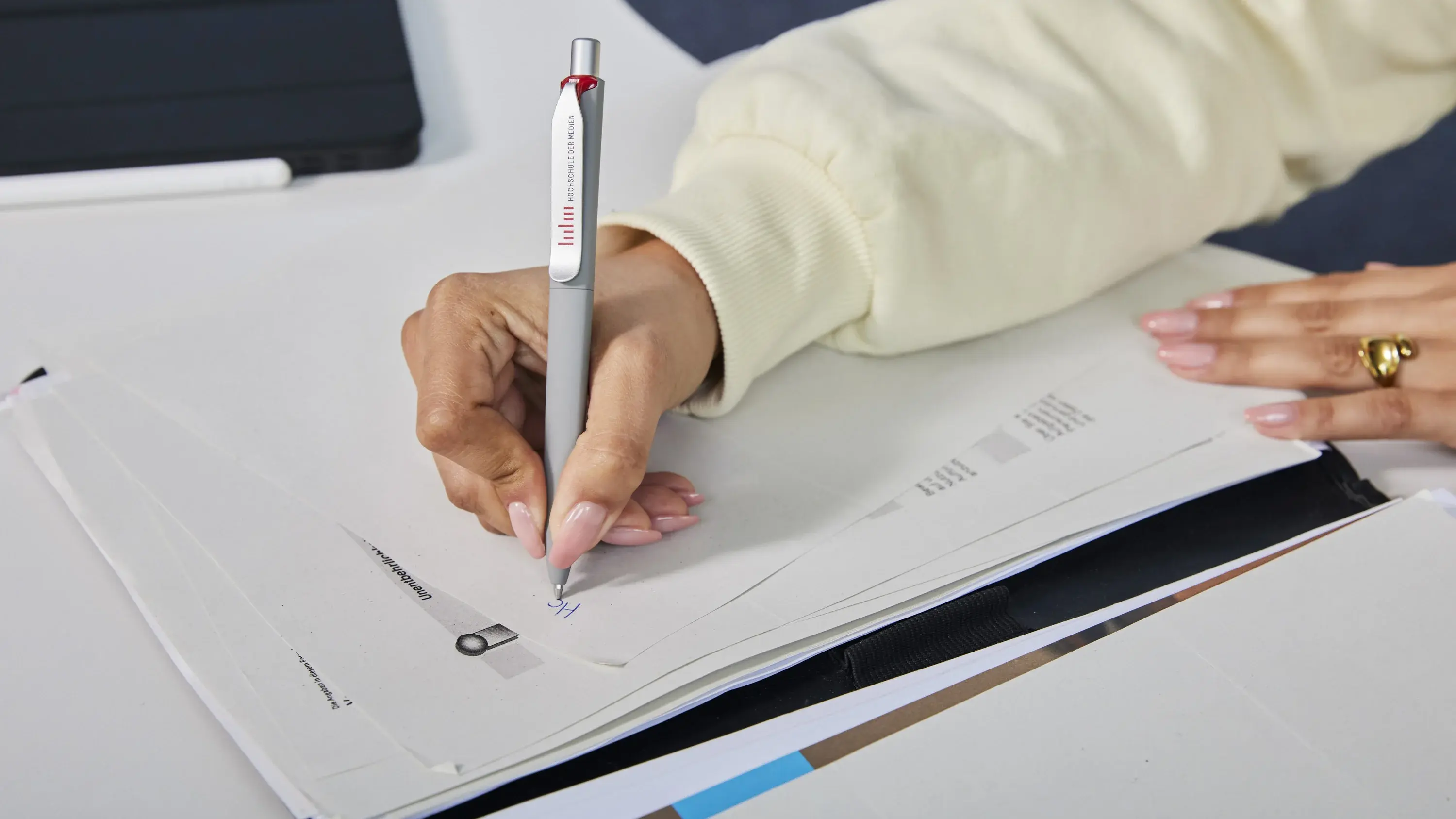 Student writing notes on a notepad.