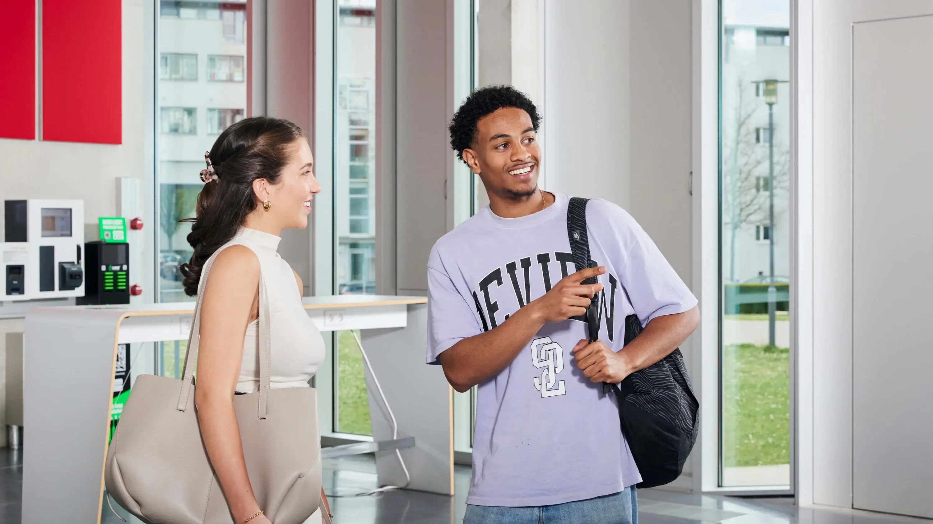 Zwei Studierende unterhalten sich auf dem Campus.