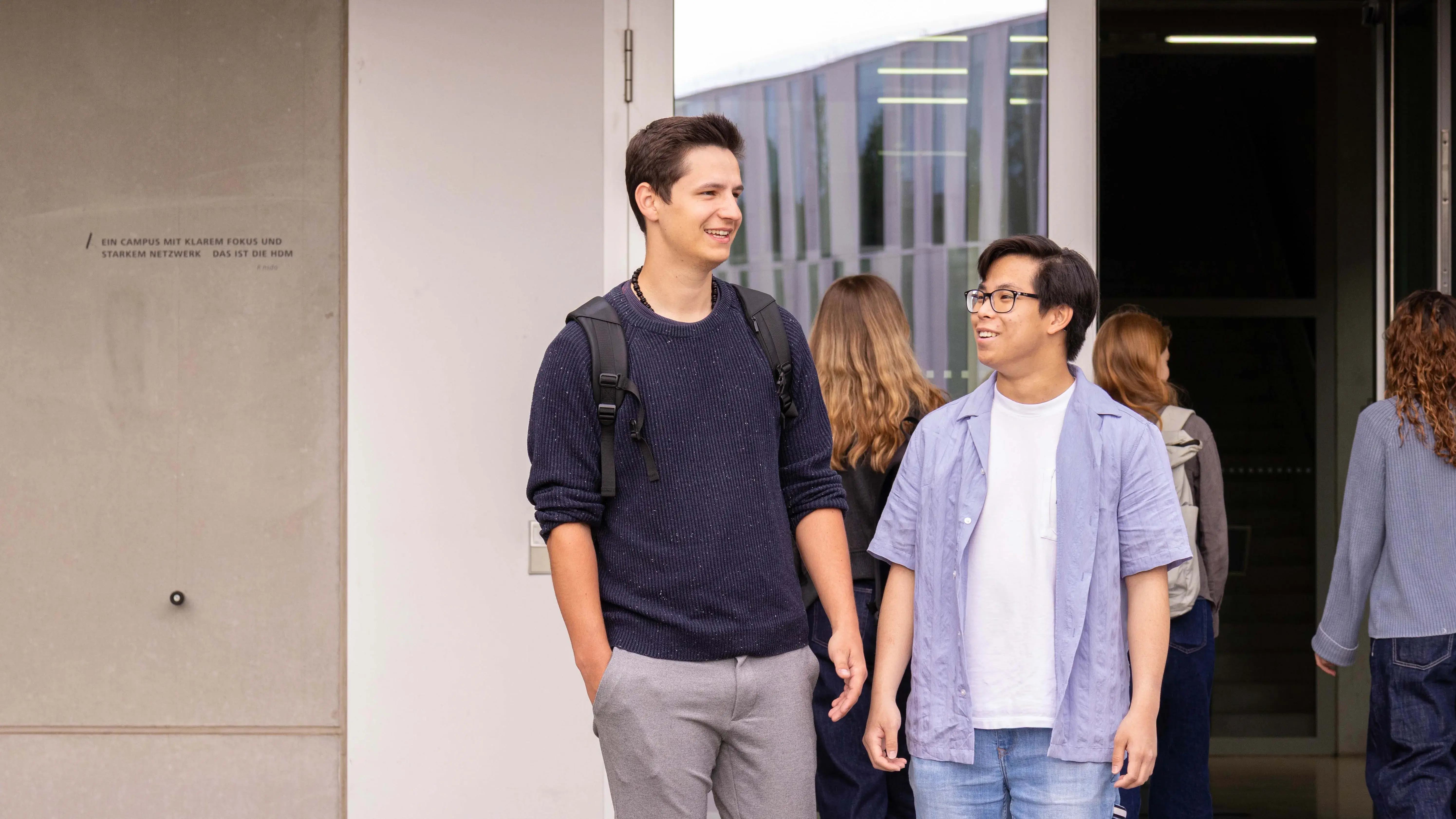 Studenten unterhalten sich beim Verlassen der Hochschule der Medien.