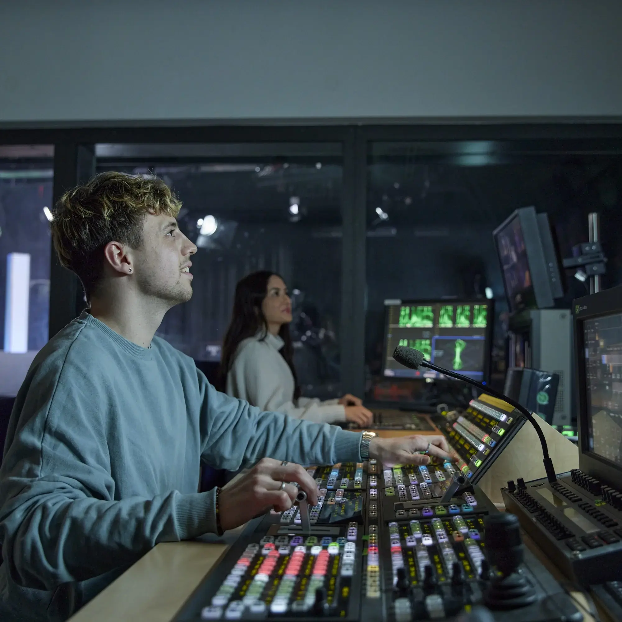 A student works in the technical room of the HdM television studio.