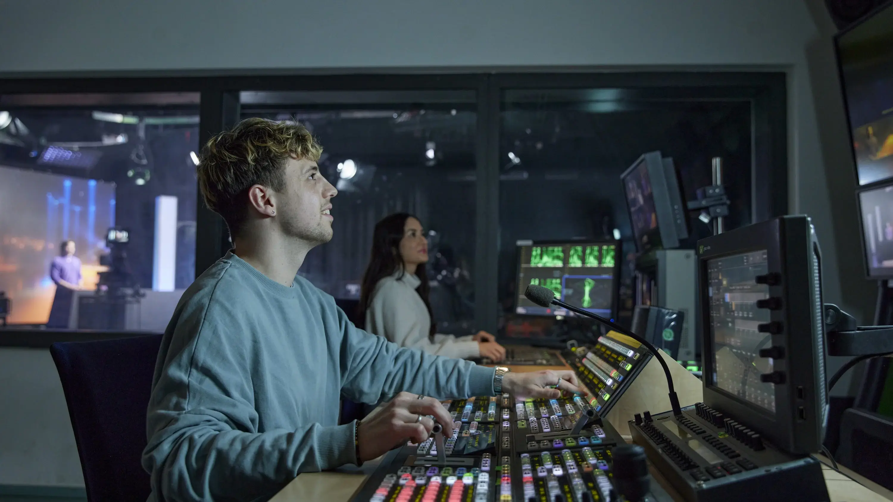 A student works in the technical room of the HdM television studio.