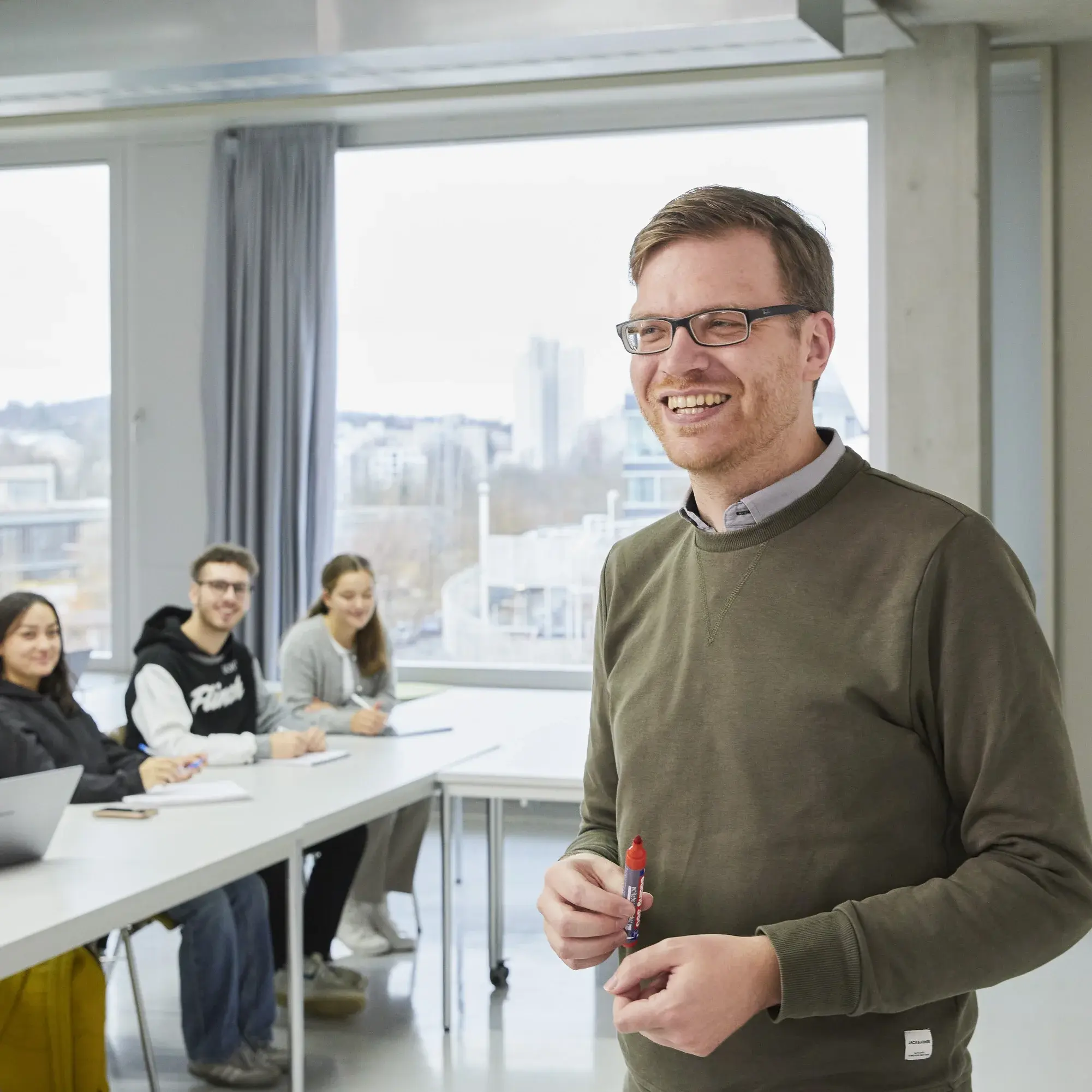 Professor smiles at the camera during a lecture.
