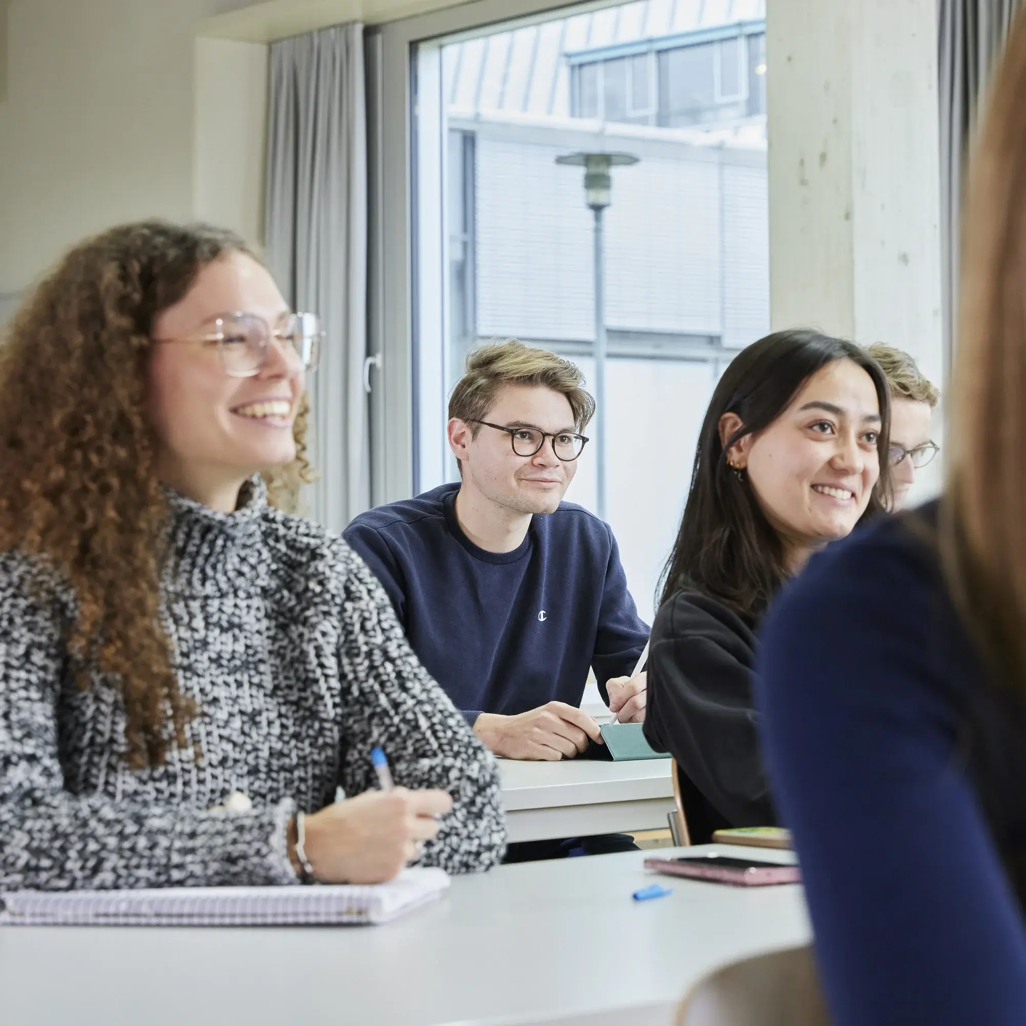 Students sit laughing in a lecture.