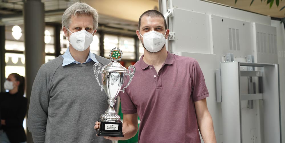 Teambild des des Gewinnerteams OMM. Zu Sehen sind Prof. Wilczekt und Prof. Widackovic mit Pokal.