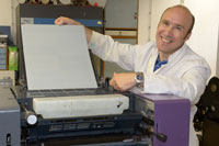 Tomislav Cigula (Universität Zagreb) spannt eine nicht entwickelte Druckplatte in die Druckmaschine ein.