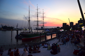 Menschen sitzen mit Abstand am Hamburger Hafen