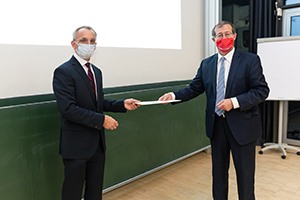 Mit Maske und Abstand: Prof. Dr. Alexander W. Roos (rechts) übergab die Urkunde