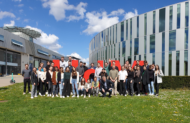 Gruppenfoto der AI Summer Camp Teilnehmerinnen und Teilnehmer am Schriftzug der Hochschule der Medien.